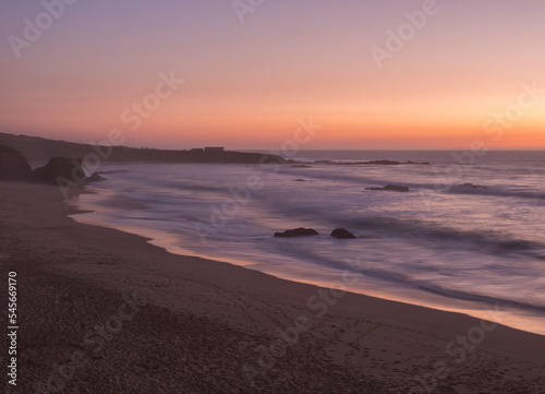 Wallpaper Mural Mysterious long exposure view of sand beach Praia Grande de Almograve with blurred ocean waves in pink orange and purple light. Blue hour after sunset at Rota Vicentina coast, Almograve, Portugal Torontodigital.ca