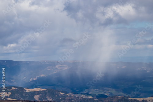 Rainclouds moving across the valley and the mountains of Seckauer Alps seen from Saualpe, Carinthia, Austria, Europe. Dark clouds accumulating and storm emerging. Thunder and rain over Central Alps