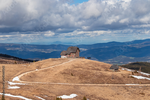 Panoramic view of mountain hut Wolfsbergerhuette (Wolfsberger Huette) on Saualpe, Lavanttal Alps, Carinthia, Austria, Europe. Alpine road leading to remote cottage. Panorama on Wolfsberg and Koralpe photo