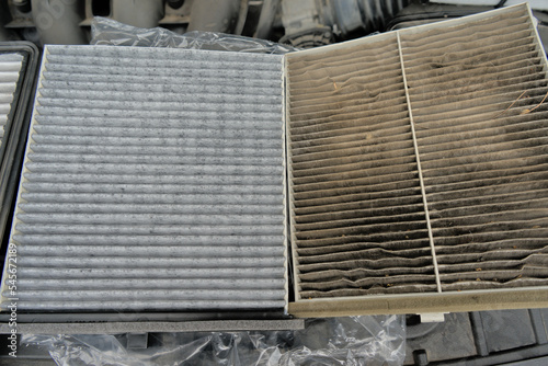 A new car air filter and an old one with garbage in the hands of a man. Comparison and preventive replacement in the car.