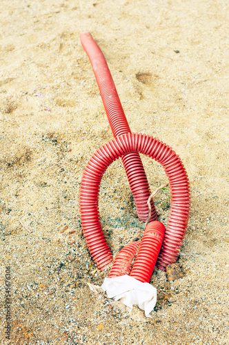 wires and insulation hoses stick out of the ground, vertical shot.