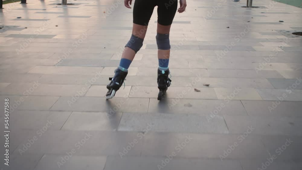 Back view of skater girl riding on rollerblades. Back view of skater girl riding on rollerblades.