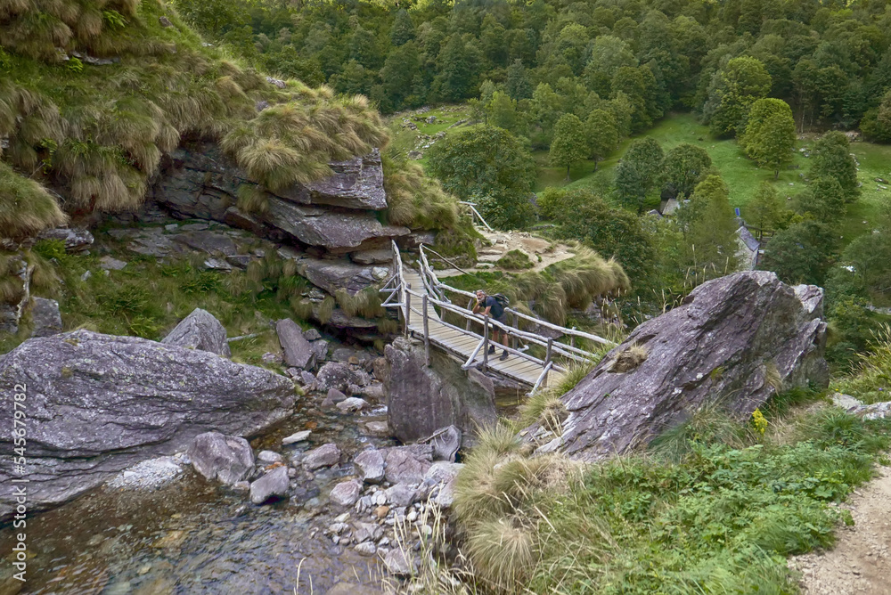 Fototapeta premium mature man old bridge, Sonogno, Switzerland