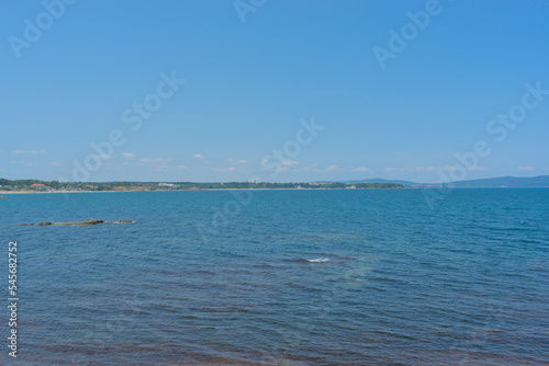 Clear water in the sea, blue sky, hills on a bright sunny day. Calm summer vacation landscape