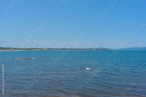 Clear water in the sea, blue sky, hills on a bright sunny day. Calm summer vacation landscape © Mariyka LnT