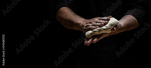 Fotografia Beautiful and strong men's hands knead the dough from which they will then make bread, pasta or pizza