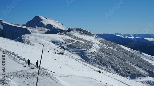 row of winter tourists, hiker in snowshoes walk in the mountains in the fog