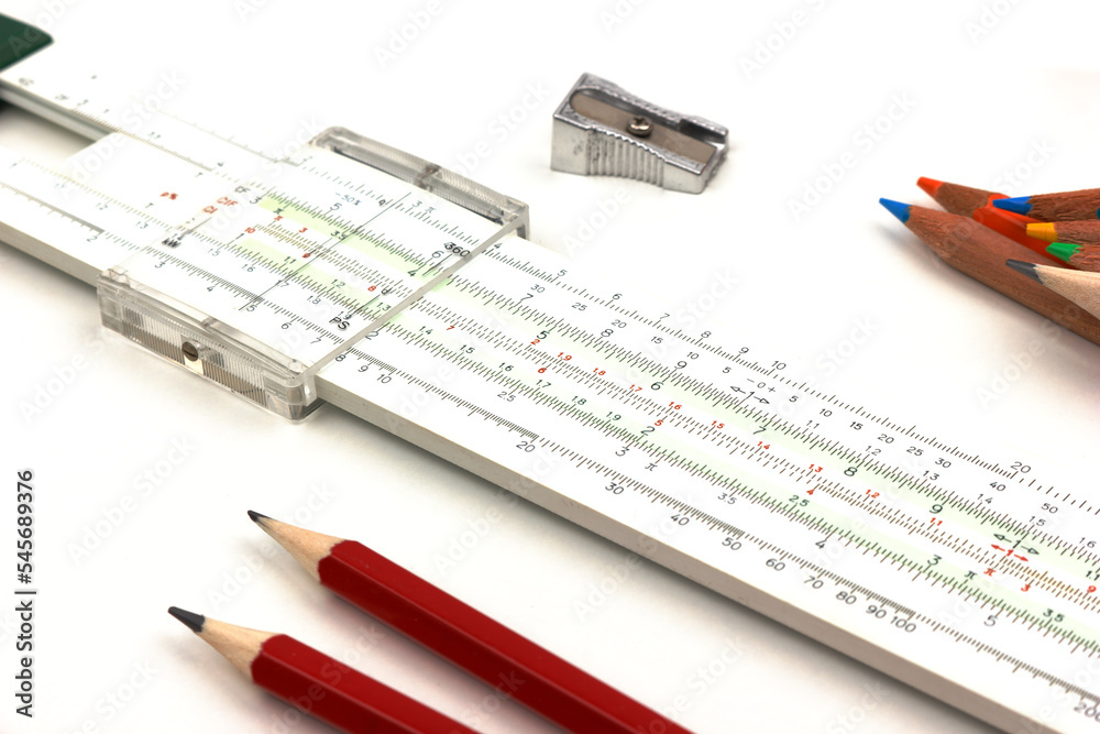 slide rule being used for calculation with pencils and sharpener isolated on white background. slide rule being used for calculation with pencils and sharpener isolated on white background.