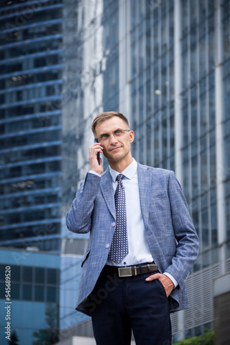 Business man with a phone in his hands on the background of the building