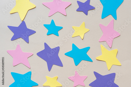 blue, pink, purple, and yellow paper stars on blank paper