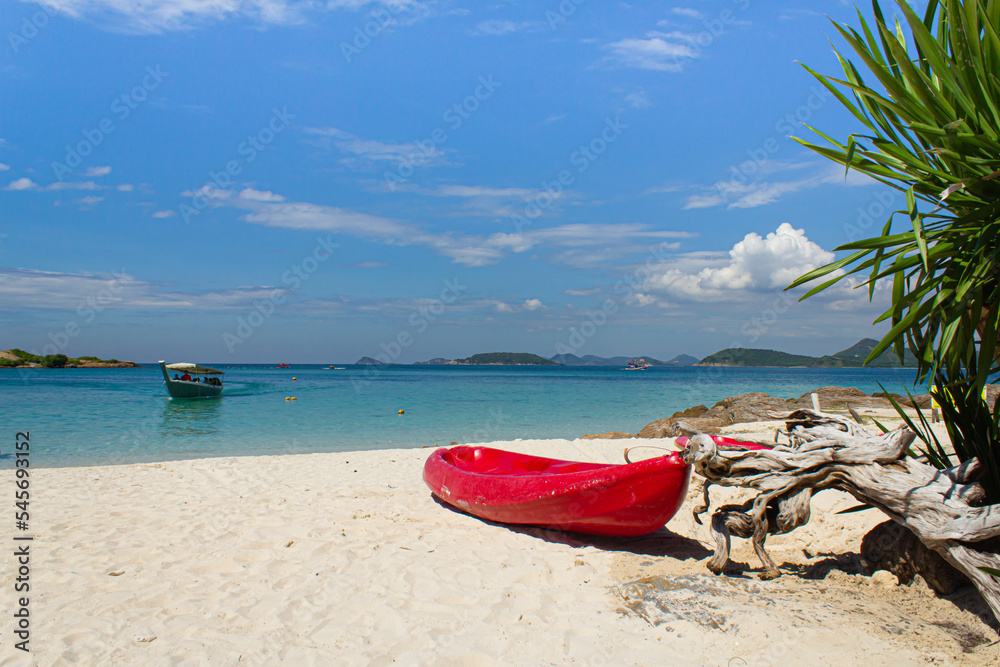 Red kayak on beach with blue sea and sky background Red kayak on beach with blue sea and sky background