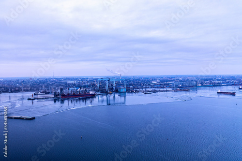 A cargo ships standing on a frozen river. Freight transportation concept  import export and business logistics  aerial view in winter. Nikolaev  Ukraine