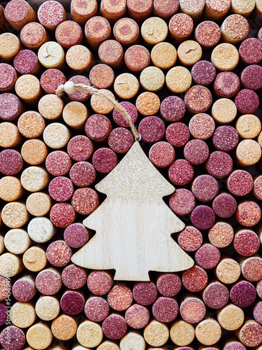 Wine corks with Christmas fir tree wooden toy as copy space, natural texture used bottle stoppers. Christmas background with close up wooden corks. New Year holidays wine concept