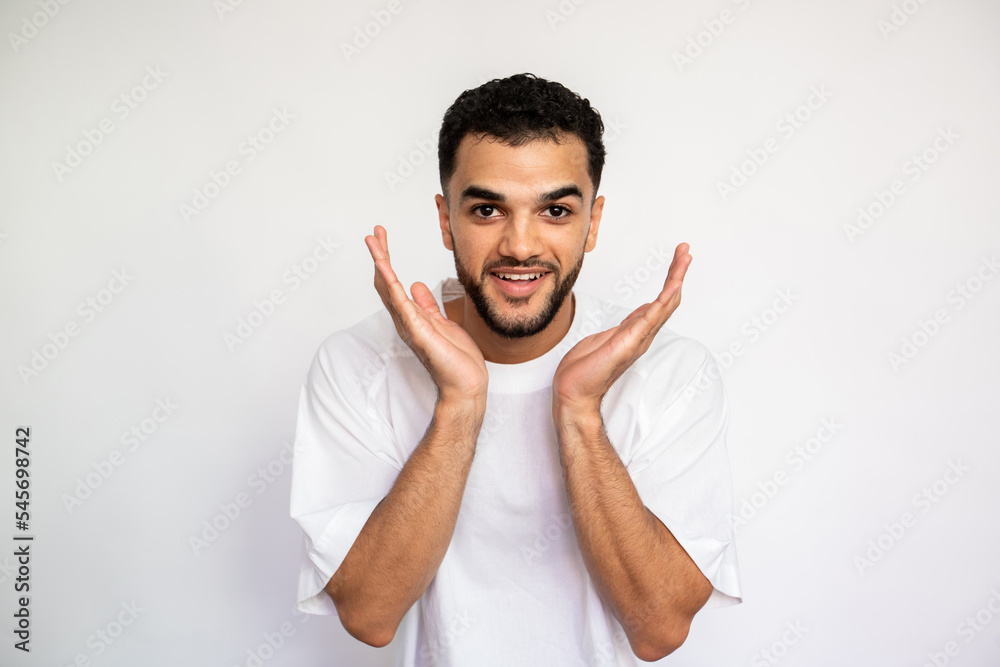 Portrait of happy young man expressing admiration. Bearded man wearing white T-shirt looking at camera and smiling over white background. Excitement concept Portrait of happy young man expressing admiration. Bearded man wearing white T-shirt looking at camera and smiling over white background. Excitement concept