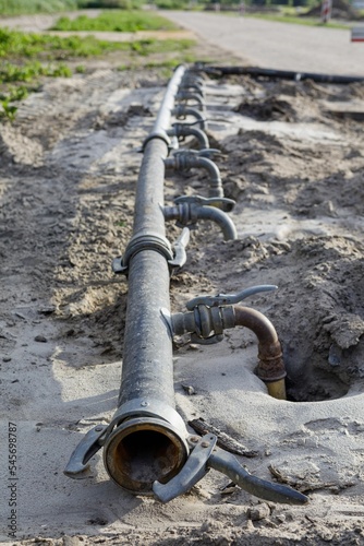 Closeup of irrigation pipes in a muddy field