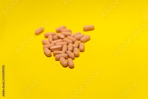 Close-up shot of scattered-brown capsules isolated on yellow background