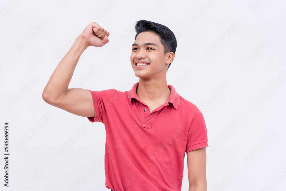 A young handsome asian man raises his hand in victory or support. Feeling optimistic and bright. Isolated on a white backdrop. A young handsome asian man raises his hand in victory or support. Feeling optimistic and bright. Isolated on a white backdrop.