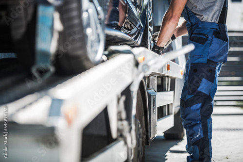 Foto Worker Securing Car on a Towing Truck