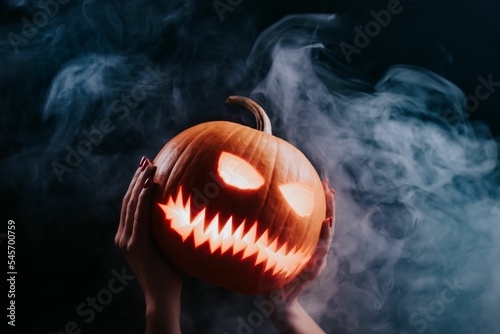 Steaming pumpkin laughing evilly - head of jack-o-lantern with carved eyes