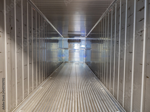 Truck body from inside. Truck body with cooling system. Container with gray walls. Container for transporting food. Body of truck with scuffs on wall. Storage space for chilled products
