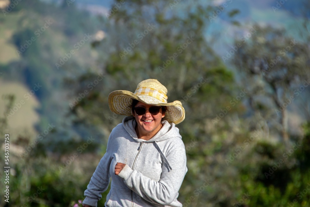 Adorable cheerful woman in a hat running around in a park