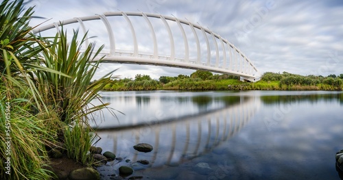 Beautiful view of the Te Rewa Rewa Bridge under a cloudy blue sky in New Plymouth, New Zealand photo