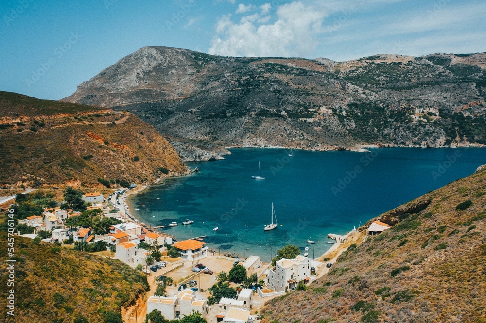 Naklejka premium Scenic mountains and blue sea port with sailing boats in Porto Kagio, Mani, Greece