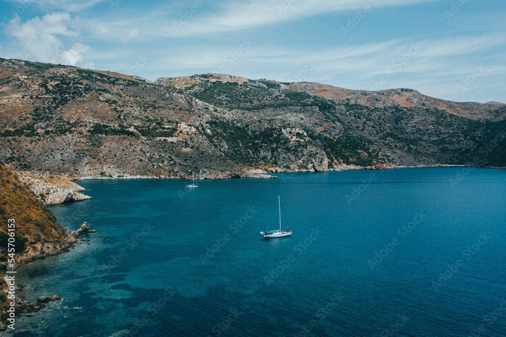 Scenic sea mountains and blue water with sailing boats in Porto Kagio, Mani, Greece