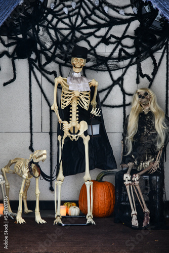 Outdoor Halloween decorations. Skeletons, pumpkins, spider and web.