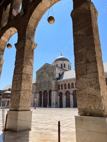 Ancient Umayyad Mosque from arch columns against the blue sky photo