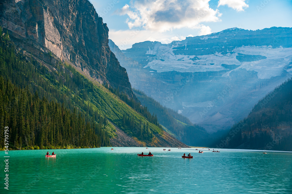 Lake Louise in the afternoon of a summer day. Green water and sun setting behind the mountains. Lake Louise in the afternoon of a summer day. Green water and sun setting behind the mountains.