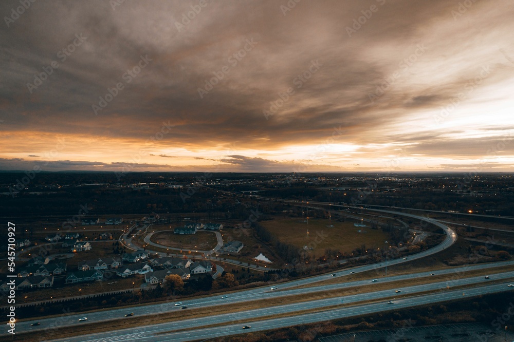 High-angle shot of a suburban neighborhood next to a freeway exit with the overcast gloomy sky above High-angle shot of a suburban neighborhood next to a freeway exit with the overcast gloomy sky above
