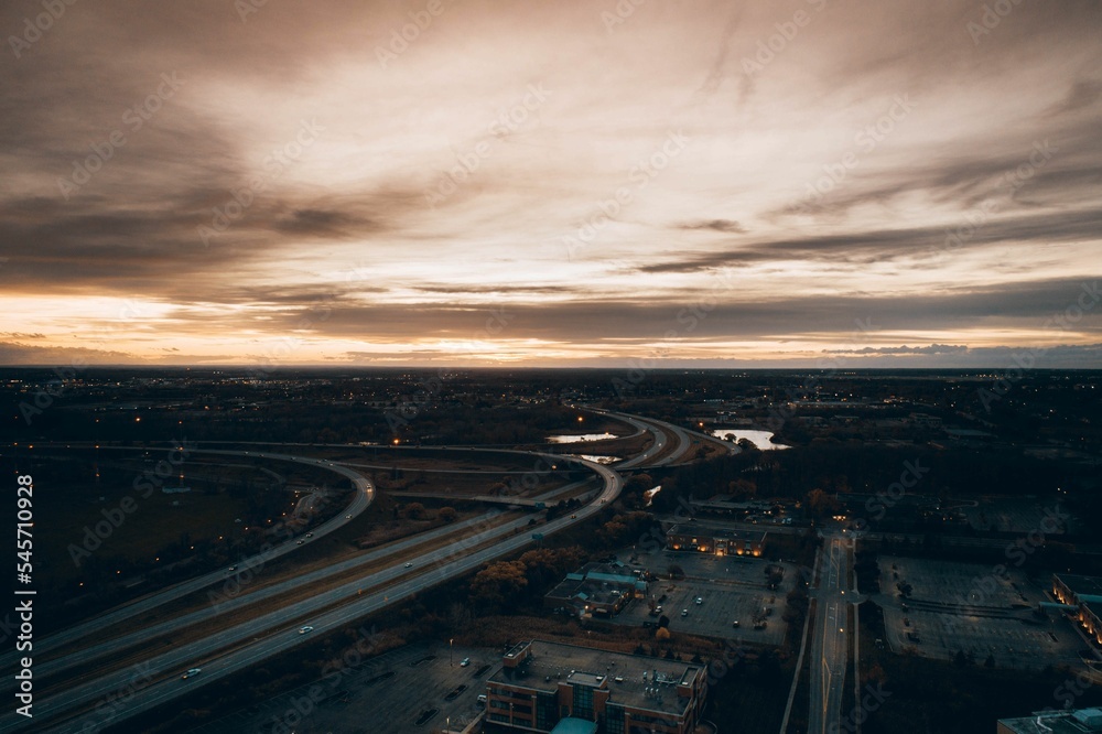 High-angle shot of a suburban neighborhood next to a freeway exit with the overcast gloomy sky above High-angle shot of a suburban neighborhood next to a freeway exit with the overcast gloomy sky above