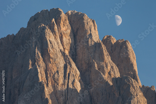 The Moon, behind the northern side of Sasso Lungo at sunset from the Val Gardena area