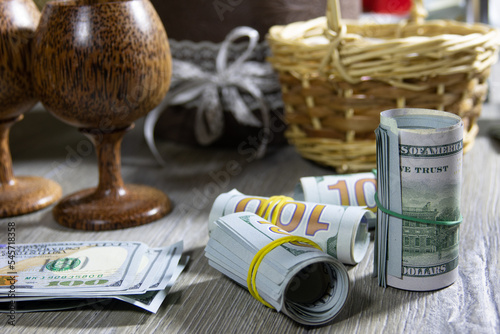 Closeup of rolled up American dollars banknotes on a gray wooden table