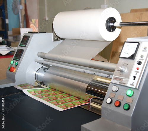 Electric industrial laminator for applying film to paper in the production shop is working
