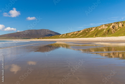 Empty beach on a sunny day at low tide. Sunny seascape from Keel Beach on Achill Island in County Mayo, Ireland.