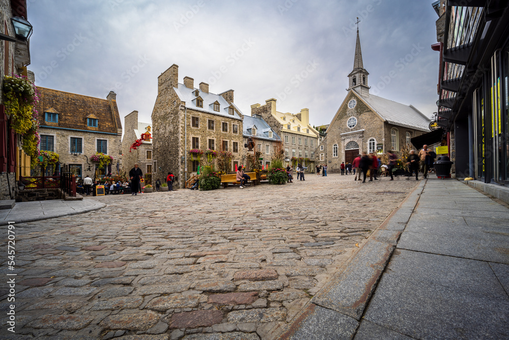 Fototapeta premium In the heart of the old town of Quebec there is the Place Royale where tourists admire the cobbled streets and stone houses of New France.