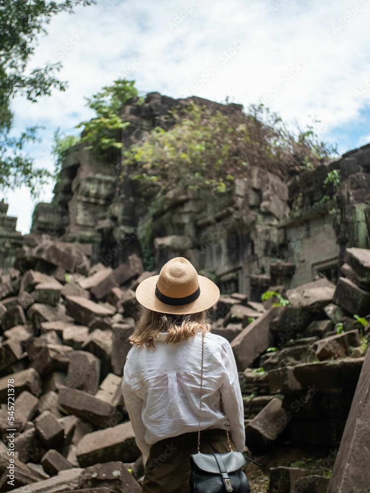 Young Australian woman with blonde hair exploring old historical ruins in daylight in Cambodia
