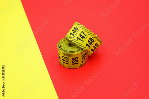 yellow measuring tape on a yellow and red background