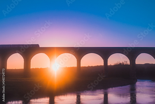 Colourful aerial view of sunrise with train travelling on Arthington Viaduct, UK © PhotographyBradley