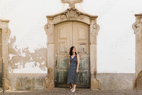 Beautiful shot of an attractive female against an old typical door in Portugal