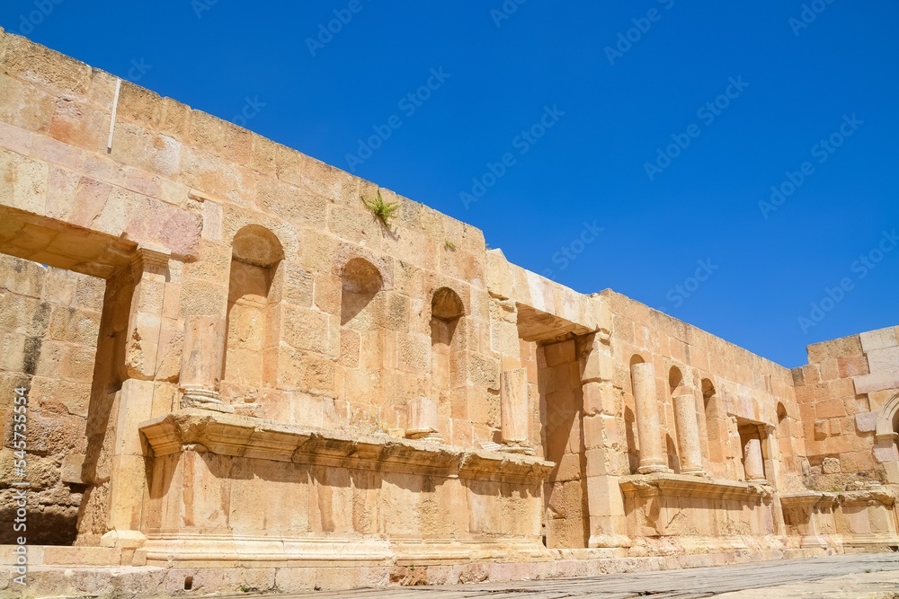 Wall of an ancient temple of Nymphaeum in the Roman city of Gerasa against the sky in Jerash, Jordan