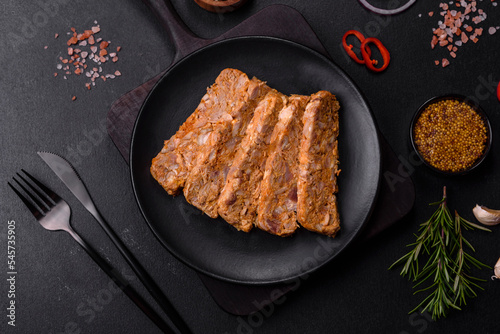 Tasty meat brawn or roll on a wooden cutting board with spices and herbs