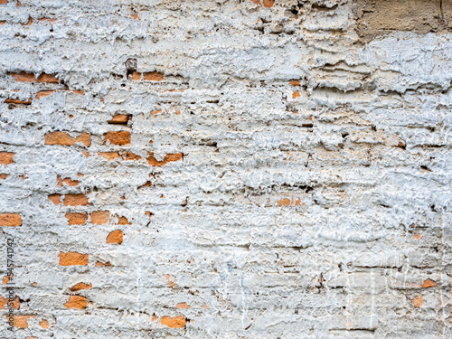 Abstract white grunge peeling cement texture on brick wall background. Old crack plaster concrete wall. Broken stonewall wallpaper.
