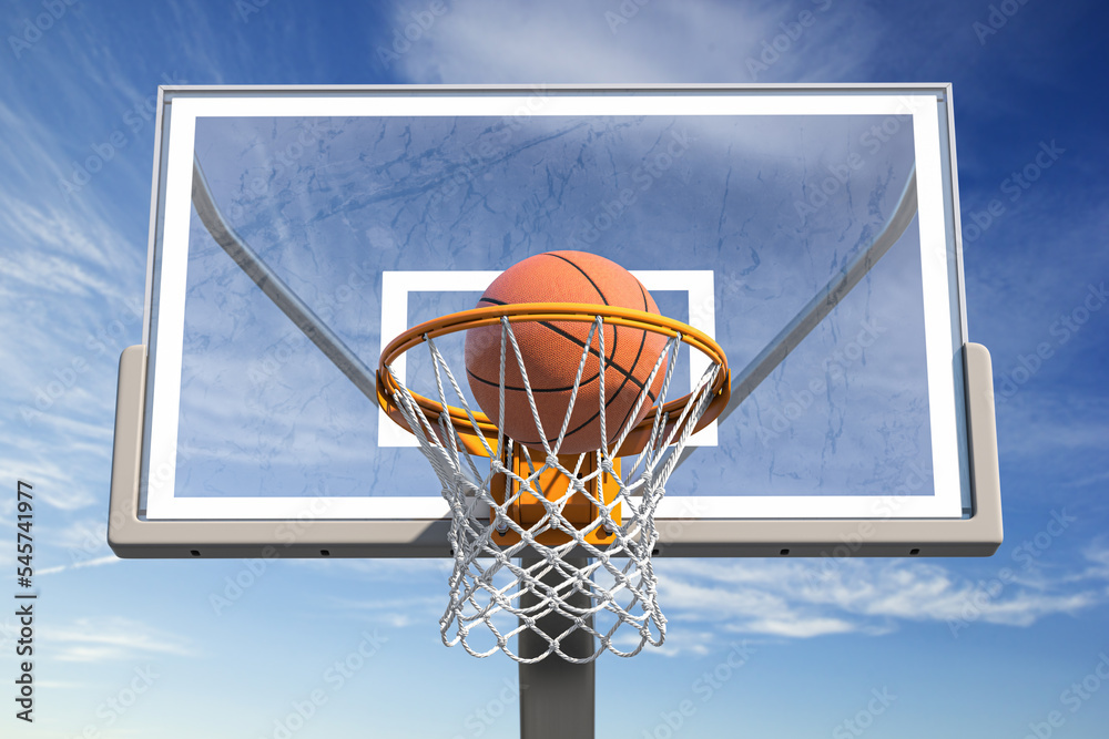 Basketball ball in tha basketball hoop on a street basketball court.