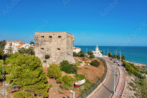 Coastal view of Oropesa del Mar, Spain, showing Torreon del Rey, guard tower and lighthouse in the background, photo