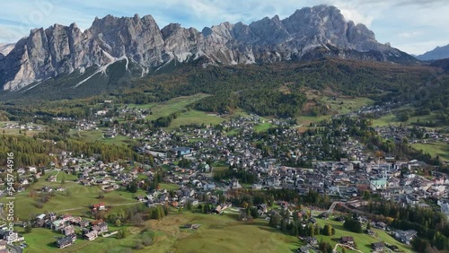 Alpine village under a mountain range in the center of a valley. Aerial video, Cortina d' Ampezzo, in the center of the Dolomites. photo