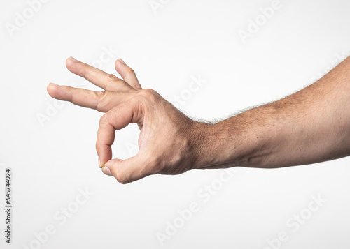 A man's hand and arm on a nuclear white background, showing a gesture of greeting approval or positivity.