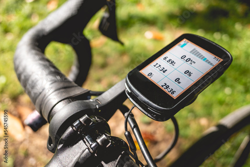 Details of the handlebar, brake levers and bike computer of a pro bike in the park in a sunny day photo